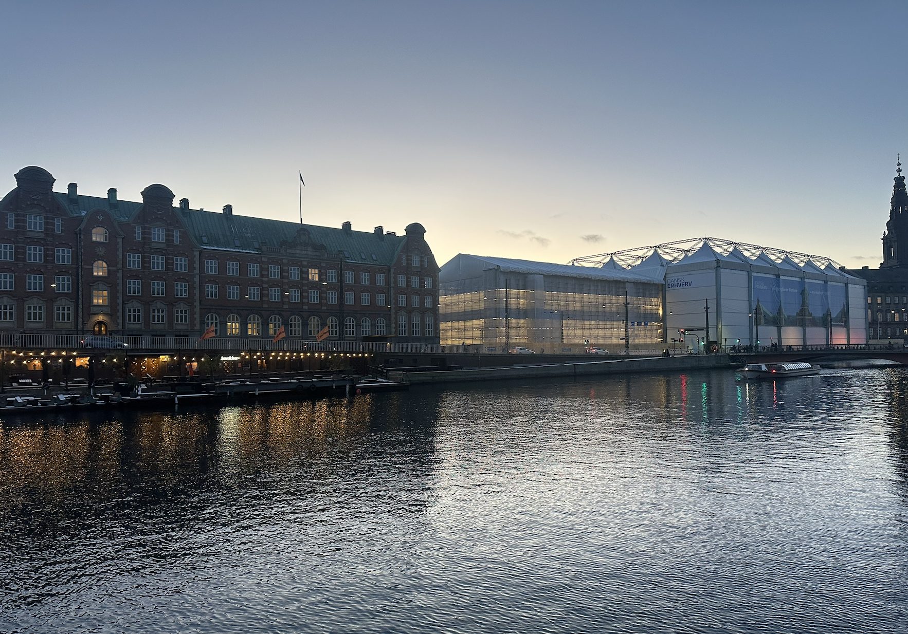 Canal de Slotsholmen al atardecer en Copenhague, con el histórico edificio de la Bolsa (Børsen) cubierto por una carpa de protección