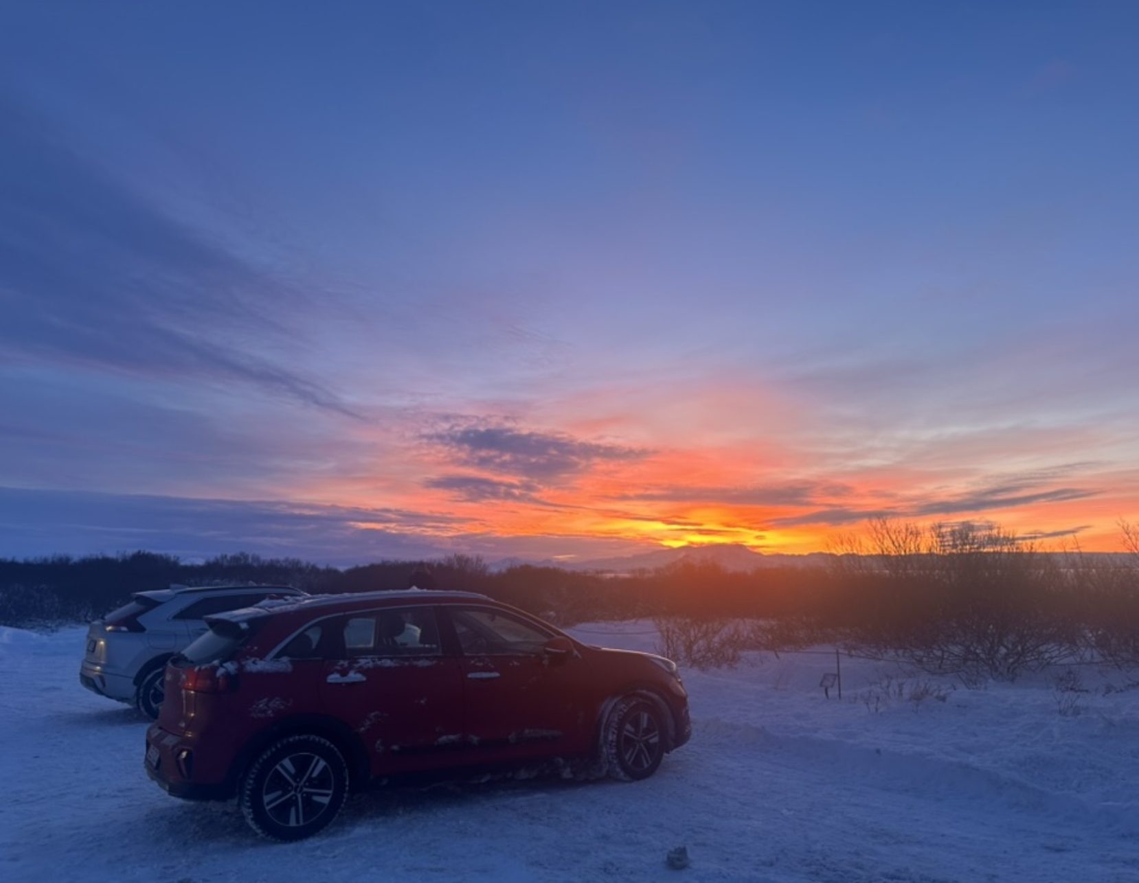 Atardecer de colores intensos visto desde un parqueadero nevado en Islandia