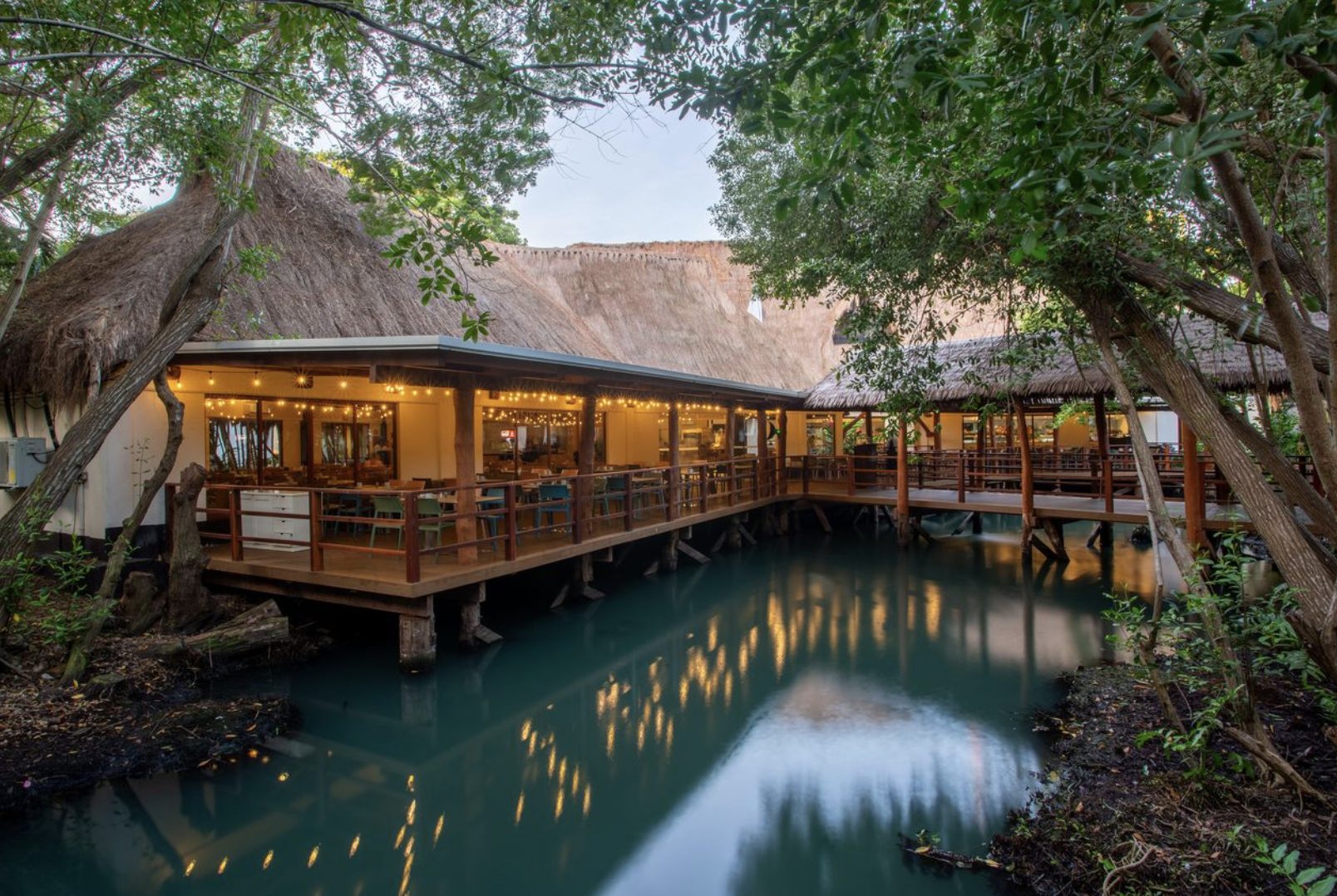 Restaurante sobre pilotes en medio de la selva y una laguna en Sandos Caracol Eco Resort, Riviera Maya